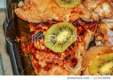 Meat with kiwi fruit. Fried chicken pieces with kiwi slices on a grill pan. Meat with kiwi fruit. Fried chicken pieces with kiwi slices on a grill pan. 121818069