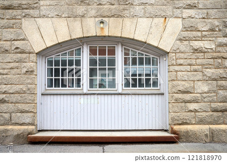 Oldwindow. Architecture of an old window in a brick wall. Facade of vintage white or classic windows on a house. Exterior details of a traditional, rustic residential building with light stone walls. Oldwindow. Architecture of an old window in a brick wall. Facade of vintage white or classic windows on a house. Exterior details of a traditional, rustic residential building with light stone walls. 121818970