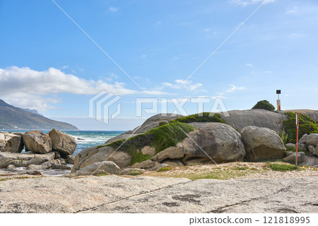 Copy space, sea and ocean rocks on a remote, quiet and serene beach in a relaxing tropical coastal destination with a mountain background. Seascape, blue sky and tidal water on secluded island abroad Copy space, sea and ocean rocks on a remote, quiet and serene beach in a relaxing tropical coastal destination with a mountain background. Seascape, blue sky and tidal water on secluded island abroad 121818995