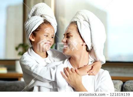 Happy, smiling and relaxed mother and daughter spa day at home with face masks for healthy skincare and personal hygiene. Cute little girl and parent bonding and enjoying a pamper treatment together 121819139