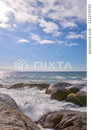 Waves crashing against rocks in the ocean under a blue cloudy sky with copy space. Scenic landscape of boulders or big stones in the sea at a popular summer location in Cape Town, South Africa Waves crashing against rocks in the ocean under a blue cloudy sky with copy space. Scenic landscape of boulders or big stones in the sea at a popular summer location in Cape Town, South Africa 121819394