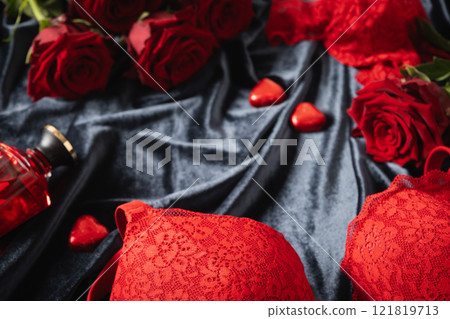 Romantic dating. Valentine's day, lace women's red underwear, lingerie, massage oil and red roses on dark. Weekend for adult. Close up. Romantic dating. Valentine's day, lace women's red underwear, lingerie, massage oil and red roses on dark. Weekend for adult. Close up. 121819713