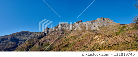Twelve Apostles at Table Mountain in Cape Town against a blue sky background from below. Breathtaking view of plants and shrubs growing around a majestic rocky valley and scenic landmark in nature 121819740