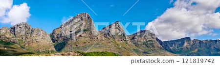 Mountain landscape against a cloudy blue sky background with copy space. Rocky hills and cliffs on The twelve apostles in Cape Town, Western Cape. Beautiful travel destination and tourist attraction 121819742