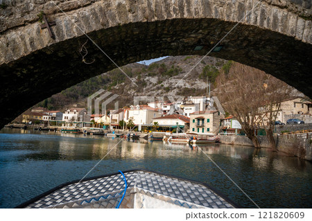 View from boat under arched bridge over Crnojevic river of small town near Skadar lake in Montenegro in winter time 121820609