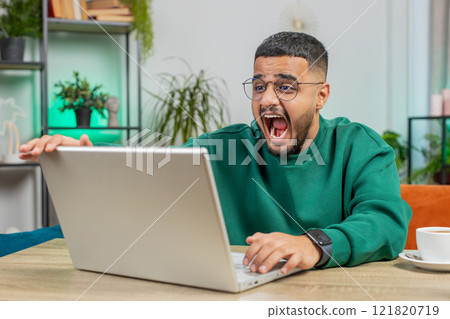 Angry Indian man use laptop surprised by bad news, fortune loss, game fail, lottery results at home 121820719