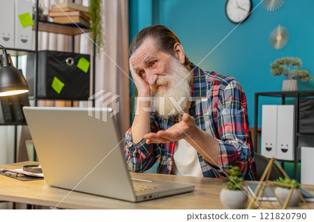 Displeased sad senior man using laptop receive bad news loss game fail computer virus at home office Displeased sad senior man using laptop receive bad news loss game fail computer virus at home office 121820790