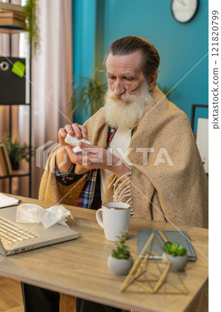 Sick ill senior man suffering from cold flu allergy blows sneezes wipes snot works on laptop at home Sick ill senior man suffering from cold flu allergy blows sneezes wipes snot works on laptop at home 121820799