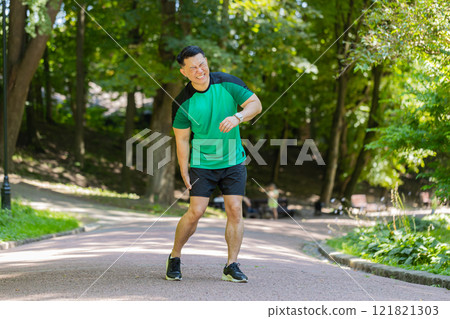 Chinese runner sportsman with muscle knee pain in park trauma injury while jogging leg muscle cramp Chinese runner sportsman with muscle knee pain in park trauma injury while jogging leg muscle cramp 121821303