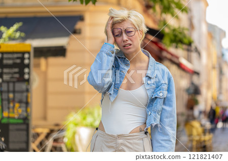 Sad unhappy young woman thinks over life concerns, suffers from unfair situation on city street 121821407