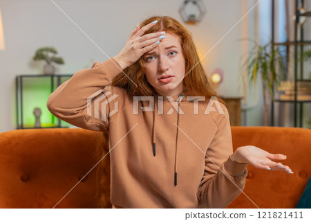 Upset woman making disrespect gesture, disappointed in fail results bad news on sofa couch at home Upset woman making disrespect gesture, disappointed in fail results bad news on sofa couch at home 121821411