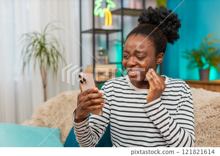 African American woman experiencing toothache, looking distressed, using smartphone searching clinic 121821614