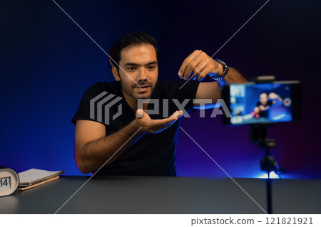 Broadcaster talking on live streaming with blurred screen smart phone. Surmise. Broadcaster talking on live streaming with blurred screen smart phone. Surmise. 121821921