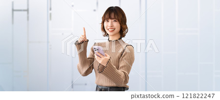 一位微笑的女商人拿著智慧型手機並提供指導 一位微笑的女商人拿著智慧型手機並提供指導 121822247