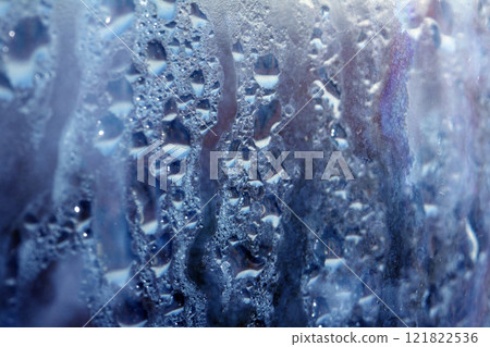 Deilcate Rain Drops of Water on Glass in a Blue Glow for Background 121822536