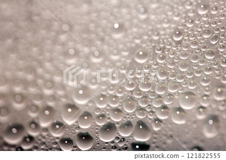 Close Up of Condensation Floating Liquid Water Bubbles and Drips on Glass from Rain Close Up of Condensation Floating Liquid Water Bubbles and Drips on Glass from Rain 121822555