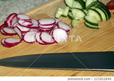 Chopped Up SlicedCuecumber and  Radish on a Chopping Board in a Kitchen 121822648