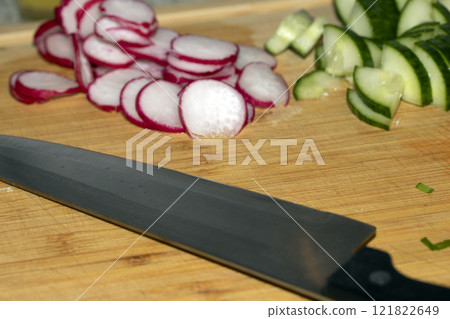 Chopped Up SlicedCuecumber and  Radish on a Chopping Board in a Kitchen 121822649