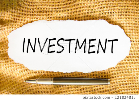 Investment symbol. Concept word Investment on beautiful white paper. Beautiful canvas background. Beautiful black pen. Business investment concept. Copy space. Investment symbol. Concept word Investment on beautiful white paper. Beautiful canvas background. Beautiful black pen. Business investment concept. Copy space. 121824813