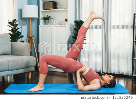 Flexible and dexterity woman in sportswear doing reverse gaiety yoga position 121825246