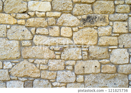 Sturdy yellow and beige cut stone wall, seamless lined up 121825736