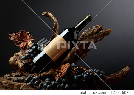 Bottle of red wine with empty label on a old snags. Bottle of red wine with empty label on a old snags. 121826074