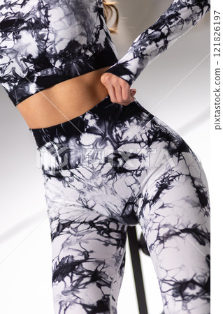 Stylish black and white abstract pattern activewear close-up, seamless leggings and top, fashion concept Stylish black and white abstract pattern activewear close-up, seamless leggings and top, fashion concept 121826197