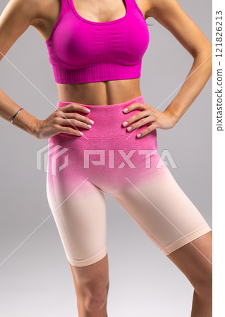 Woman in Sporty Pink Outfit Displaying Fitness and Style, hands on hips, athletic shape concept 121826213
