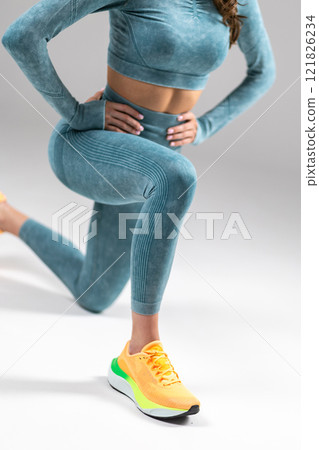 Woman in teal yoga outfit, performing lunge exercise, wearing vibrant sneakers, focus on athleticism and style, fitness fashion concept Woman in teal yoga outfit, performing lunge exercise, wearing vibrant sneakers, focus on athleticism and style, fitness fashion concept 121826234