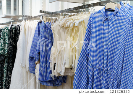 Unique clothing display showcases stylish summer attire in a bright store Unique clothing display showcases stylish summer attire in a bright store 121826325