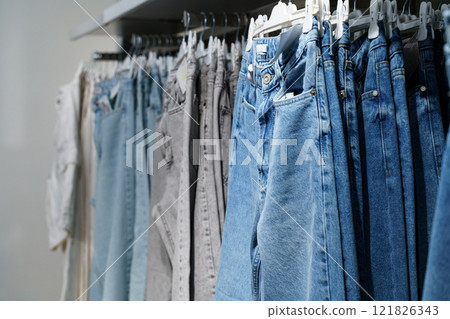 Stylish denim collection hangs neatly in a modern retail space 121826343