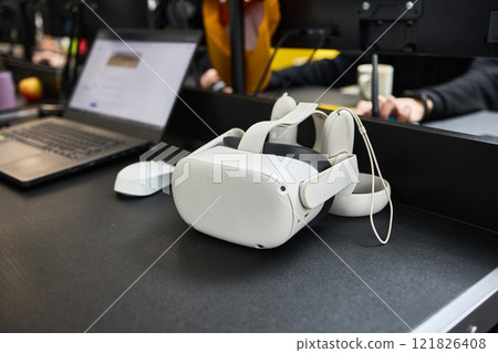 Virtual reality headset and laptop on modern office desk, technology workspace, innovative tech concept 121826408
