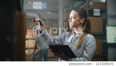 Female Warehouse Associate Scans Cardboard Boxes, Checks Delivery Information on Tablet Computer 121826676