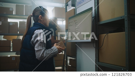 Female Parcel Processing Specialist Checks Package Delivery Information at Postal Terminal Female Parcel Processing Specialist Checks Package Delivery Information at Postal Terminal 121826703