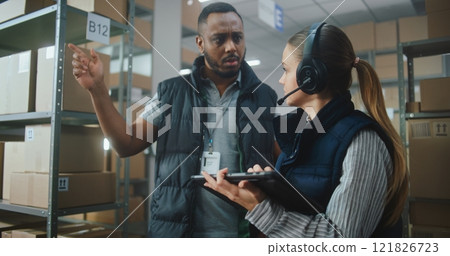Female Logistics Coordinator Uses Tablet Computer, African American Supervisor Helps Colleague 121826723