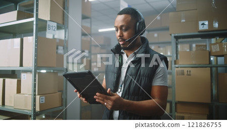 African American Customer Support Specialist in Logistics Talks on Call with Client, Uses Tablet Computer 121826755