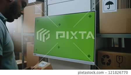 African American Inventory Manager Scans Cardboard Box. Digital Screen with Chroma Key 121826770