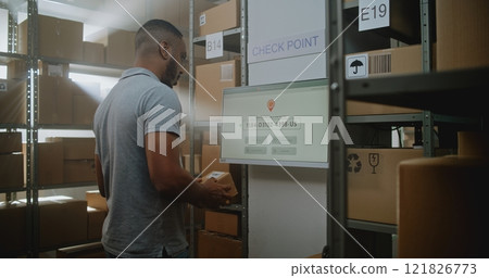 African American Parcel Processing Specialist Checks Delivery Information at Postal Terminal 121826773