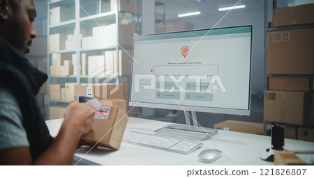 African American Warehouse Associate Scans Code, Checks Parcel Information on PC 121826807