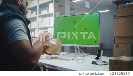 African American Warehouse Associate Scans Code on Parcel. PC Screen with Green Screen Mock Up 121826815