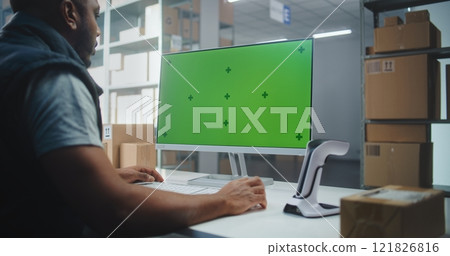 African American Warehouse Associate Scans Code on Parcel. PC Screen with Green Screen Mock Up 121826816