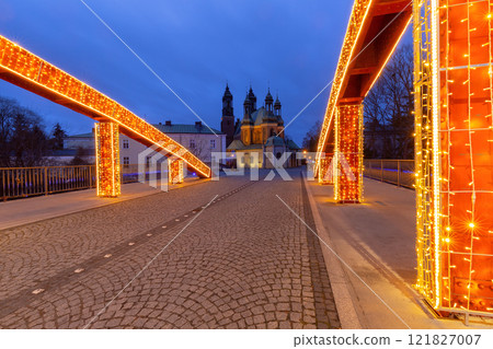 Illuminated bridge to the cathedral on Tumski Island at sunrise, Poznan, Poland 121827007