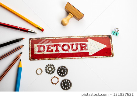 Detour. Red direction arrow with text on white office desk Detour. Red direction arrow with text on white office desk 121827621