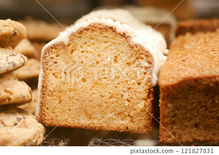 A Freshly Baked Loaf Cake Adorned with Icing and Accompanied by Cookies 121827831