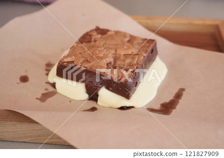 Enjoy a Delicious Brownie served with Melting Ice Cream on Brown Paper Enjoy a Delicious Brownie served with Melting Ice Cream on Brown Paper 121827909