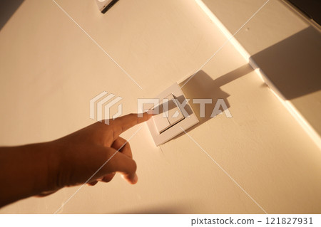 A finger turning on lighting switch . A finger turning on lighting switch . 121827931