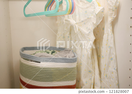 Cozy Childrens Closet featuring Beautiful Dresses and a Decorative Basket 121828007