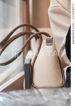 A Stylish and Elegant Handbag Placed on a Table Within a Cozy Setting A Stylish and Elegant Handbag Placed on a Table Within a Cozy Setting 121828014