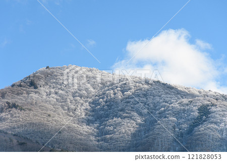 A lightly snow-covered mountain and blue sky 121828053