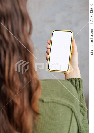close-up woman in green sitting indoors using smartphone. mock-up of smartphone 121828668